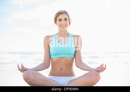 Entspannte blonde Frau in Sportbekleidung Yoga zu praktizieren Stockfoto