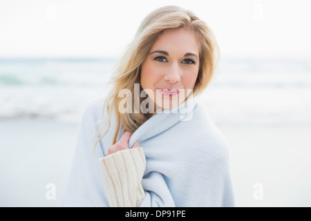 Blonde Frau, die sich in eine Decke für Inhalte Stockfoto