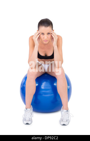 Besorgt Fit Frau sitzen auf Gymnastikball Stockfoto