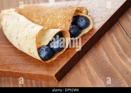 hausgemachte Blinis oder Pfannkuchen mit Heidelbeeren auf Holztisch Stockfoto