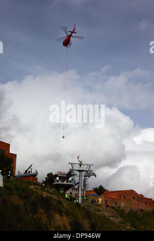 EL ALTO, Bolivien, 9. Januar 2014. Ein AS 350 B3 Ecureuil Helikopter gehören zu den bolivianischen Luftwaffe (FAB) nähert sich das Terminal in El Alto tragen eine synthetische Lichtkabel zwischen Pylonen der neuen Seilbahn / Gondel lift derzeit im Bau, El Alto, La Paz zu verknüpfen. Dies ist der erste Teil des Prozesses, das endgültige Stahlseil zu installieren, das Gondeln tragen wird. Drei separate Seilbahn Linien sind geplant als Teil eines ehrgeizigen Projekts um Verkehrsstaus zu entlasten; die erste Zeile wird voraussichtlich bis März 2014 abgeschlossen sein. Stockfoto