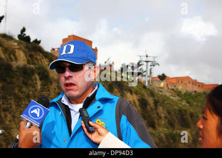 EL ALTO, Bolivien, 9. Januar 2014. Die Unidad de Transporte Por Kabel (UTC) Projekt Koordinator César Dockweiler vor der Presse während des Baus der neuen Seilbahn spricht / Gondel lift-System, die Stadt nach La Paz unten zu verknüpfen. Die Station El Alto / terminal-Gebäude ist im Hintergrund. Bildnachweis: James Brunker / Alamy Live News Stockfoto