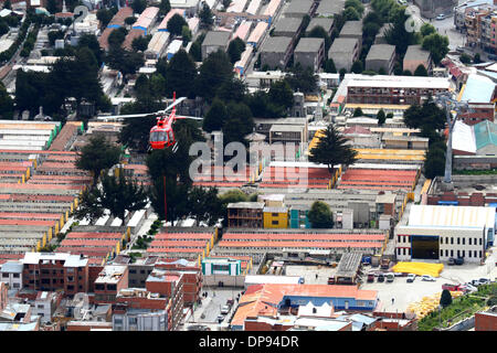 LA PAZ, Bolivien, 9. Januar 2014. Eurocopter AS 350 B3 Ecureuil Helikopter gehören zu den bolivianischen Luftwaffe (FAB) fliegt über La Paz Friedhof, da es ein synthetisches Lichtkabel zwischen Pylonen der neuen Seilbahn trägt / Gondelbahn, die derzeit im Bau, die Städte von El Alto und La Paz zu verknüpfen. Dies ist der erste Teil des Prozesses, das endgültige Stahlseil zu installieren, das Gondeln tragen wird. Drei Linien der Cable cars sind geplant als Teil eines ehrgeizigen Projekts um Verkehrsstaus zu entlasten, die erste Zeile soll bis März 2014 abgeschlossen sein. Stockfoto