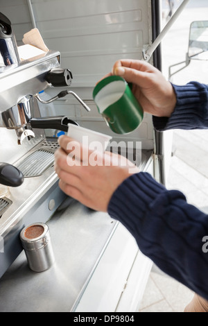 Bild Mann gießt Milch in mobilen Kaffeehaus beschnitten Stockfoto