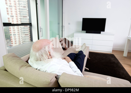 Ältere Mann vor dem Fernseher in Wohnung Stockfoto