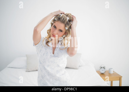 Gerne hübsche Blondine tragen Lockenwickler posiert Stockfoto