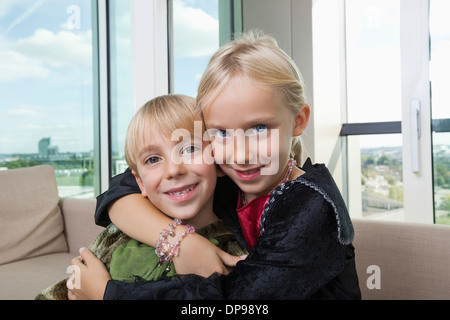 Porträt der Liebe Geschwister im Dinosaurier und Vampir Kostüme zu Hause Stockfoto