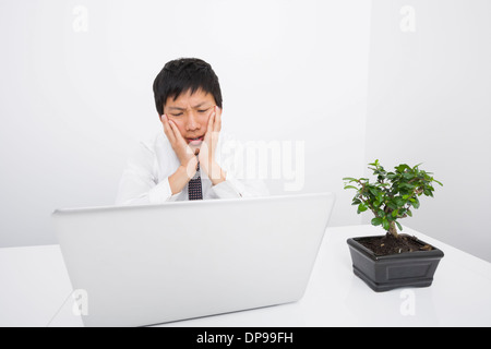 Frustriert Geschäftsmann Blick auf Laptop im Büro Stockfoto