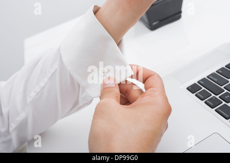 Bild der Geschäftsmann knöpfte seine Manschette im Büro beschnitten Stockfoto