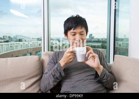 Mitte erwachsenen Mann, der Kaffeetasse im Haus Stockfoto