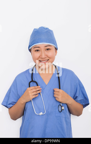 Porträt von glücklich Ärztin mit Stethoskop um Hals vor weißem Hintergrund Stockfoto