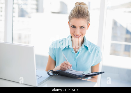 Fröhliche gut gekleidet Geschäftsfrau auf Datebook schreiben Stockfoto