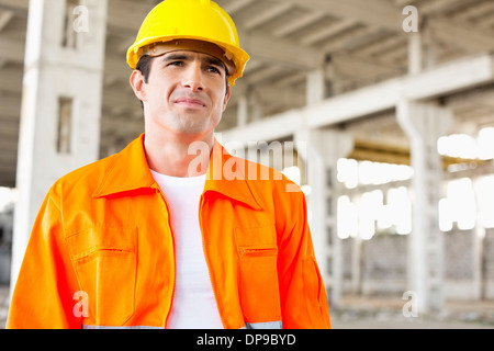 Handsome Mitte erwachsenen Mannes tragen Schutzkleidung auf Baustelle Stockfoto