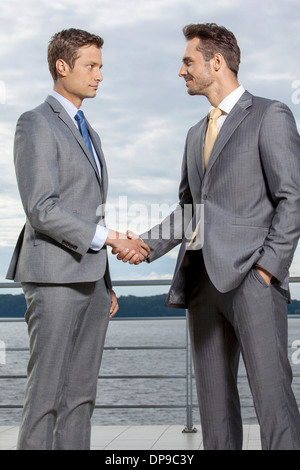 Geschäftsleute Händeschütteln auf Terrasse gegen Himmel Stockfoto