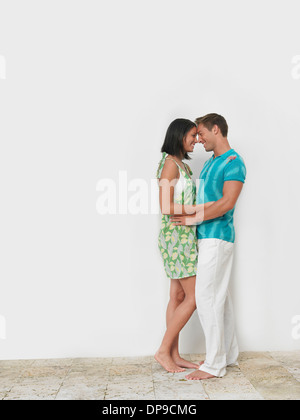 Liebevolle junge Paar stehen zusammen gegen die Wand Stockfoto