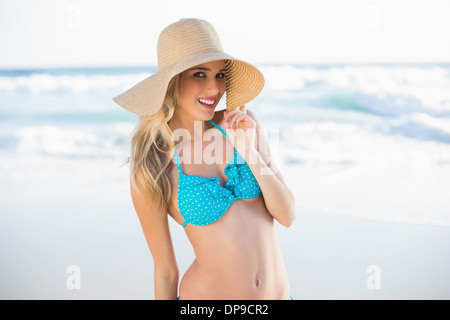 Lächeln auf den Lippen wunderschöne Blondine im Bikini tragen Strohhut Stockfoto