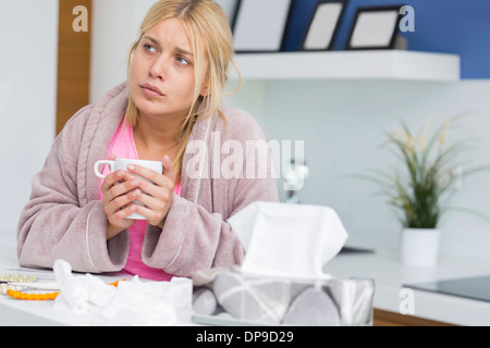 Junge Frau leidet Kälte halten Kaffee-Haferl Stockfoto
