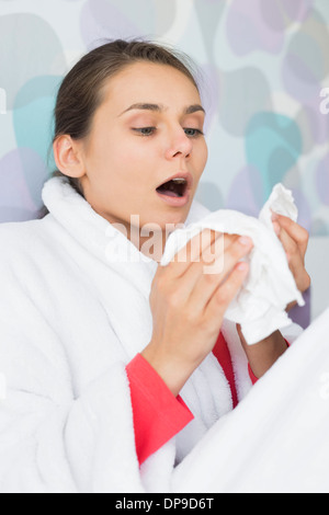 Junge Frau leidet kalt Niesen zu Hause Stockfoto