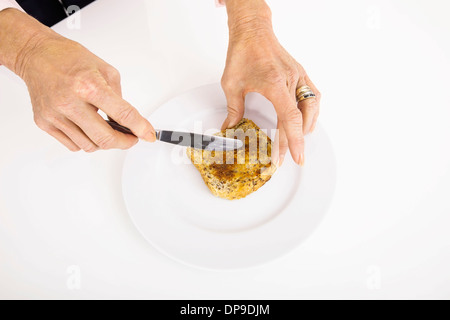 Die Geschäftsfrau Hände verteilen Butter aufs Brot Stockfoto
