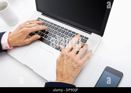 Senior Geschäftsfrau mit Laptop am Schreibtisch Stockfoto