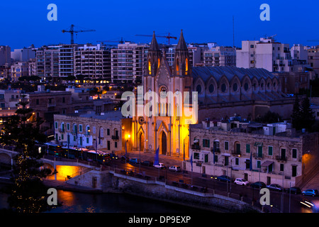 Am Abend Stadtbild mit Neo-gotischen Pfarrkirche Karmelitenkirche in Balluta Bay, St. Julian's, Insel Malta. Stockfoto