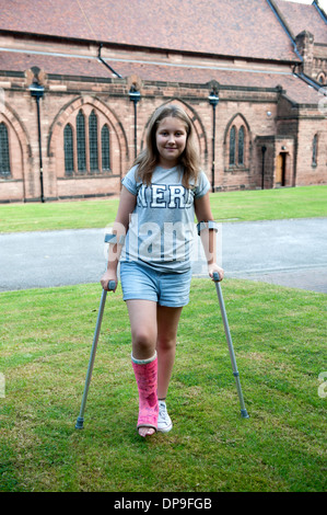 Junges Mädchen auf Krücken gebrochene Bein Gips rosa voll Modell veröffentlicht Stockfoto