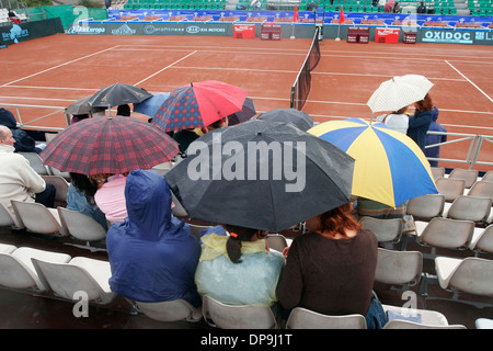 Zuschauer-Abdeckung unter ihren Regenschirmen während einer regnerischen Tag-Tennis-Turnier in Mallorca, Spanien. Stockfoto