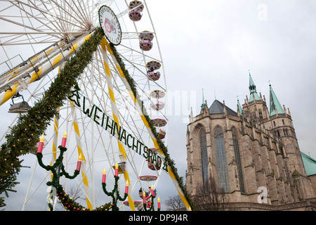 Deutscher Weihnachtsmarkt in Erfurt, Deutschland mit einem Riesenrad im Vordergrund und Str. Marys Kathedrale im Hintergrund. Stockfoto