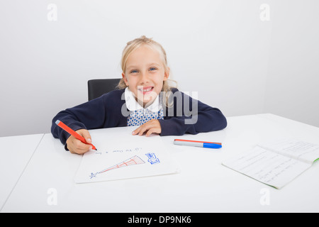 Porträt von glücklichen Mädchen Zeichnung auf Papier am Tisch Stockfoto