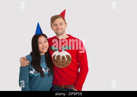 Porträt des multiethnischen Brautpaar tragen Partyhüte zu Hause Stockfoto