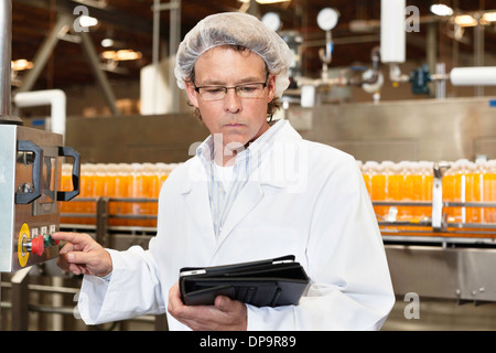 Mann, Blick auf Tablet-PC während der Arbeit in der Fabrik Abfüllung Stockfoto