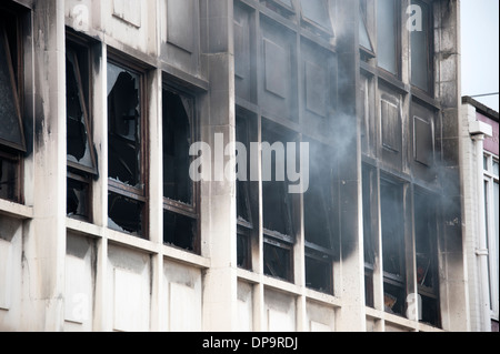 Rauch aus Windows Geschäftshauses Feuer gießen Stockfoto