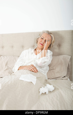 Ältere Frau leiden unter Kopfschmerzen, die Ruhe im Bett Stockfoto