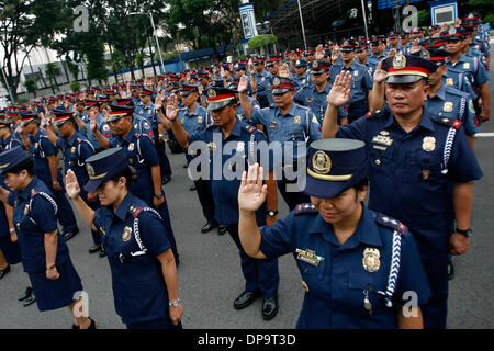 Quezon City, Philippinen. 10. Januar 2014. Aufsteiger Polizisten und Polizistinnen der Philippine National Police (PNP) statt ihren Eid während das Anlegen der Reihen im Camp Crame in Quezon City, Philippinen, 10. Januar 2014. Eine Gesamtmenge von 11.093 Offiziere der PNP wurden ernannt, um höhere Ränge auf den Philippinen. Bildnachweis: Rouelle Umali/Xinhua/Alamy Live-Nachrichten Stockfoto