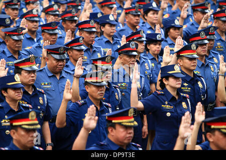 Quezon City, Philippinen. 10. Januar 2014. Aufsteiger Polizisten und Polizistinnen der Philippine National Police (PNP) statt ihren Eid während das Anlegen der Reihen im Camp Crame in Quezon City, Philippinen, 10. Januar 2014. Eine Gesamtmenge von 11.093 Offiziere der PNP wurden ernannt, um höhere Ränge auf den Philippinen. Bildnachweis: Rouelle Umali/Xinhua/Alamy Live-Nachrichten Stockfoto