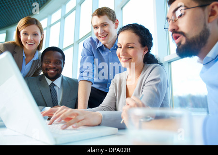 Gruppe von Geschäftspartnern Blick erstaunlich auf Laptop Display Tagung Stockfoto