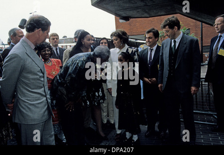 Präsident Nelson Mandela spricht mit Charles, Prinz von Wales, zu einem kleinen Mädchen bei seinem Besuch in Brixton, 1996 London England Stockfoto