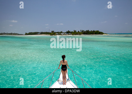 Eine junge Mutter blickt vom Boot auf die wunderschöne Insel Kandooma im Süd-Male-Atoll auf den Malediven Stockfoto