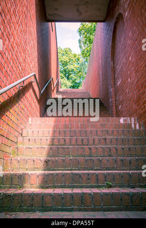 ein Tunnel wie Treppe mit roten Ziegeln und Handlauf. Stockfoto