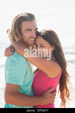 Paar am Strand umarmen Stockfoto