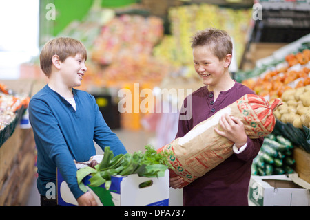 Jungen tragen Gemüse in der Markthalle Stockfoto