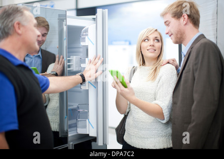 Junges Paar auf der Suche im Kühlschrank im showroom Stockfoto