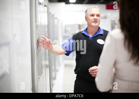 Frau betrachten Kühlschrank im showroom Stockfoto