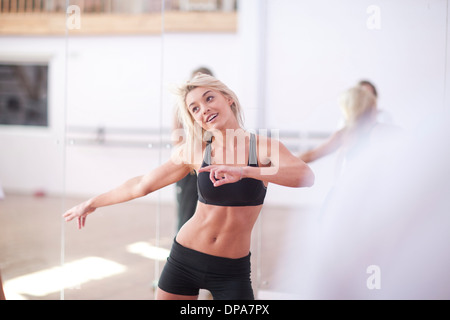 Junge Frau, die Dehnung in der aeroben Klasse Stockfoto