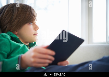 Junge auf Sofa mit digital-Tablette Stockfoto