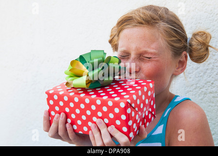 Mädchen küssen Geschenk in der hand Stockfoto