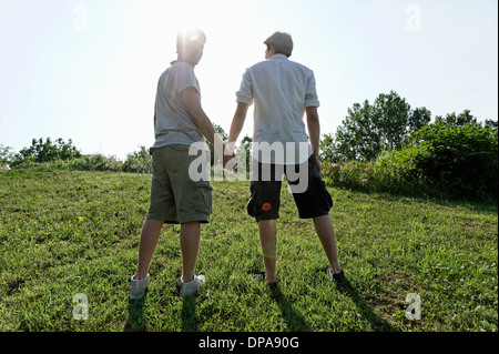 Zwei junge Männer zu Fuß und Hand in Hand Stockfoto