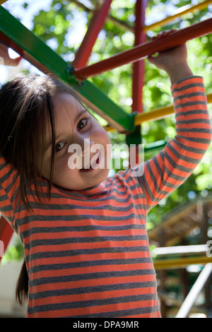 Mädchen auf Spielplatz Klettergerüst Stockfoto