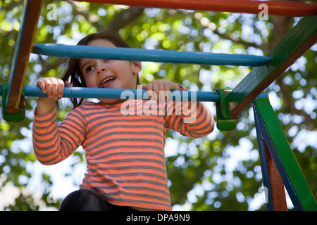 Mädchen auf Spielplatz Klettergerüst Stockfoto