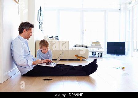 Mann mit Laptop, Sohn gerade Stock sitzt Stockfoto